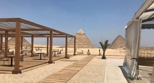 O empreendimento chamado de 9 Pyramids Lounge possui vista para as pirâmides e ônibus para guiar turistas aos principais locais de visitação